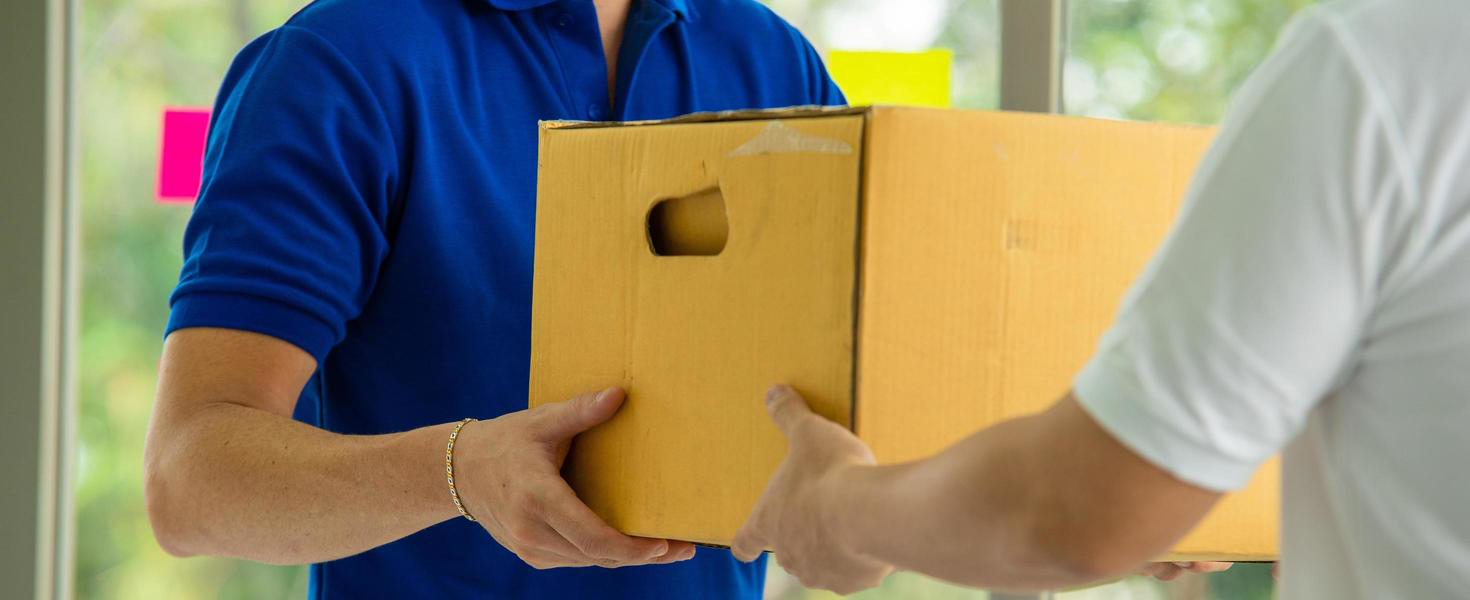 postal-worker-hands-cardboard-box-to-client-free-photo copia